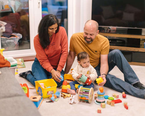 A couple and their child playing on the floor