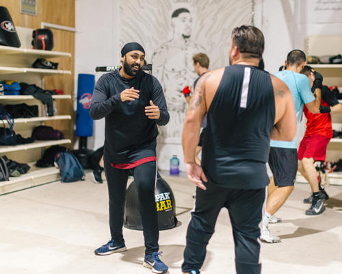 Two men sparring in a gym setting 