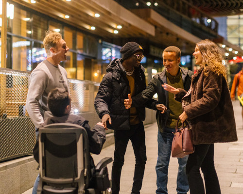 A group of older children talking outside a social setting
