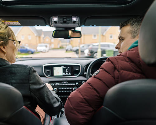 A couple glancing sideways at each other in a car