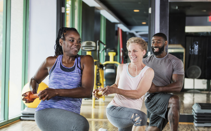Three people taking part in a weights exercise class.