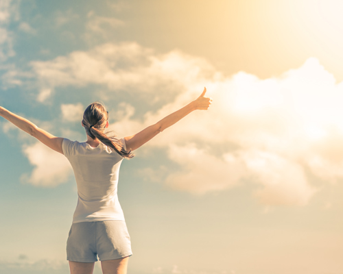 Woman with thumbs up looking at the sky