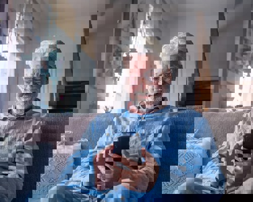Man on a sofa looking at phone